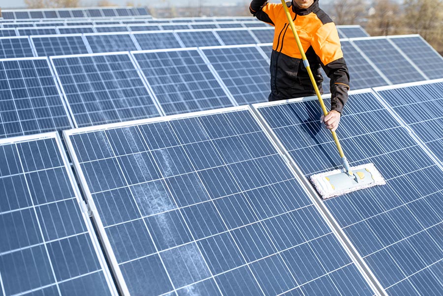 Worker cleaning a solar panel